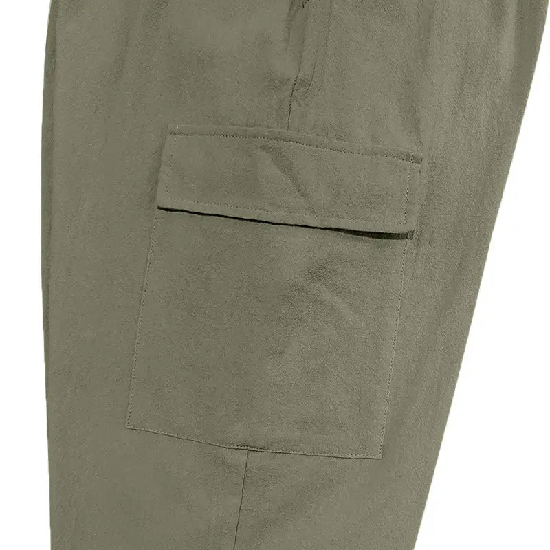 Olive green men linen cargo pants with textured fabric and reinforced stitching on the side pocket featuring a drawstring cuffed ankle.