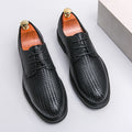 Men’s black woven leather platform British dress shoes with textured pattern and gold-toned shoe trees