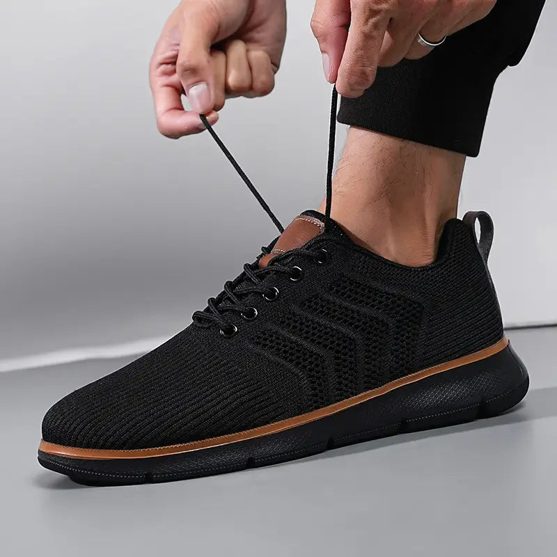 black knit mesh sneaker for men with tan accents and a textured rubber sole designed for casual flying woven shoes