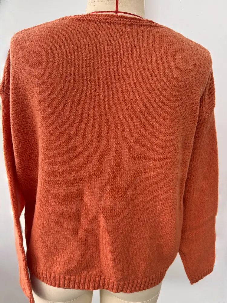 Gemütlicher Strickpullover mit V-Ausschnitt und überschnittener Schulterpartie in Rostorange, mit geripptem Halsausschnitt und Saum.
