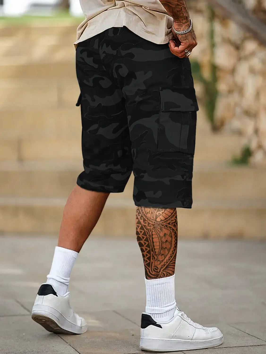 Short cargo camouflage noir pour homme, présentant une coupe ample et plusieurs poches, conçu pour un port décontracté confortable.