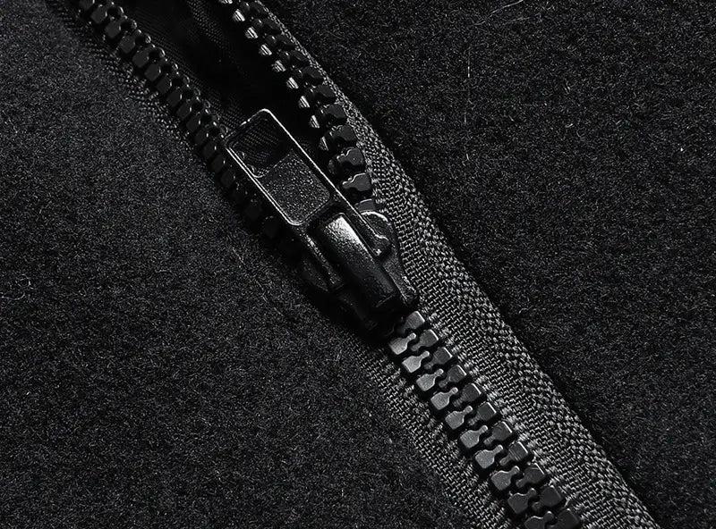 black zipper with matte finish set into dark textured fabric of men wool winter overcoat quilted jacket