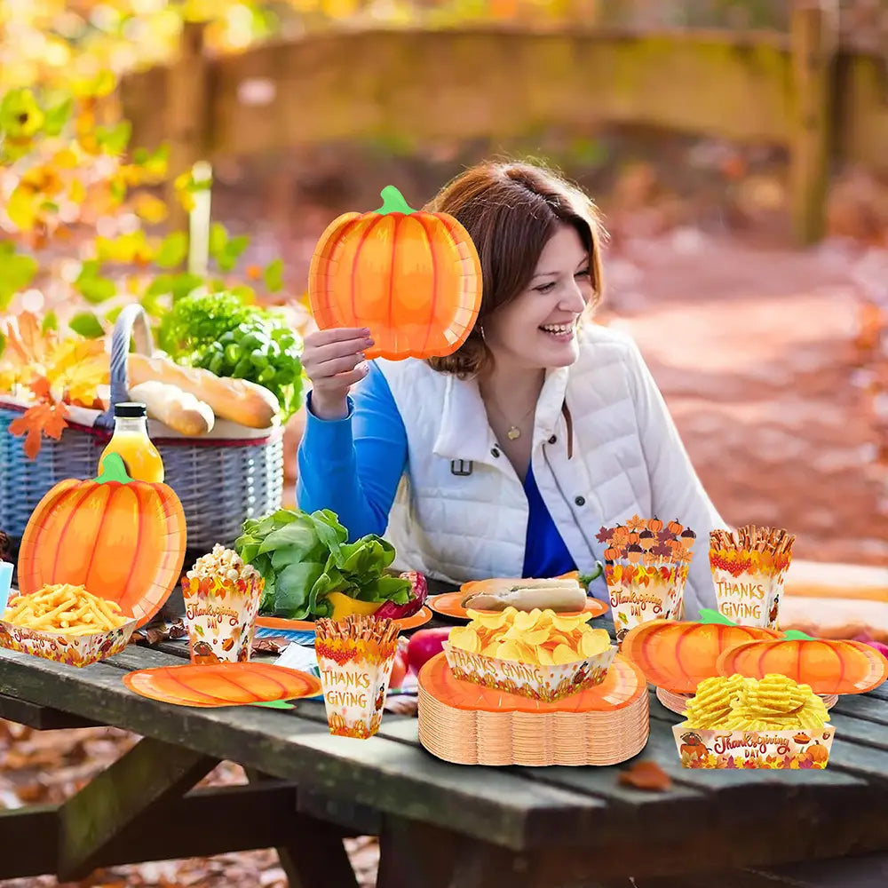 orange pumpkin-shaped paper plates with green stems and autumn leaf patterns from the thanksgiving pumpkin paper plates and tableware set for seasonal dining use.