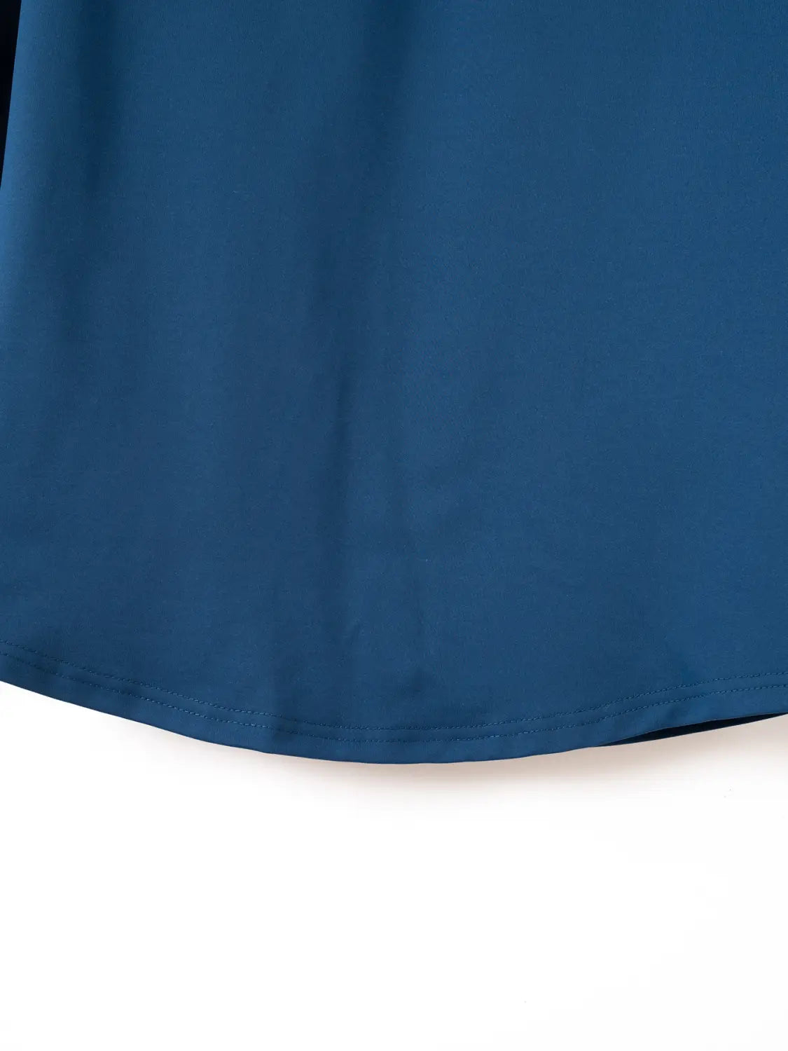 Ein glatter dunkelblauer Stoff für ein Herren-Quarter-Zip-Athletik-Poloshirt mit dezentem Schimmer und ordentlich verarbeitetem Saum.