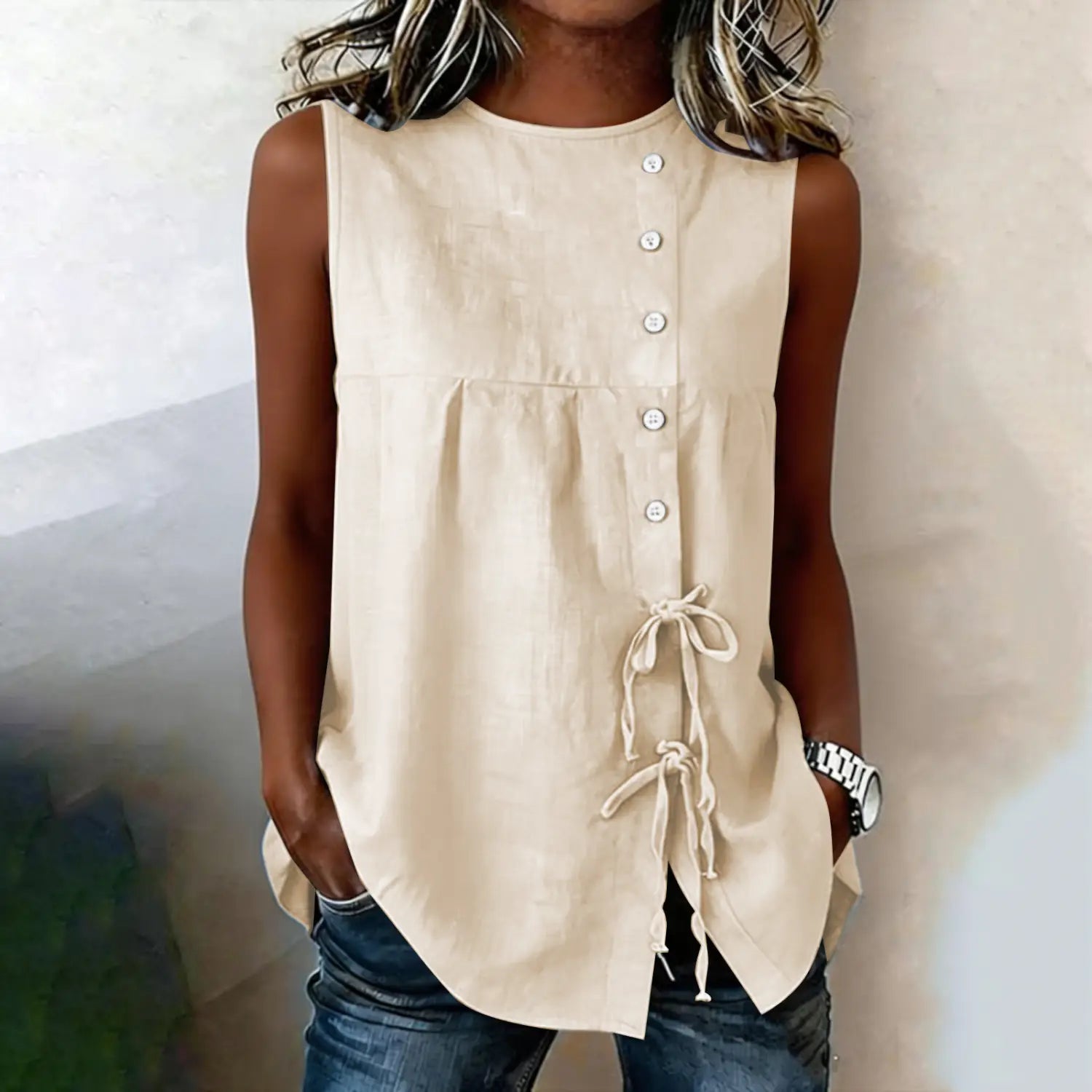 Beige sleeveless tie side button down blouse featuring a button front and side tie details made from lightweight fabric.