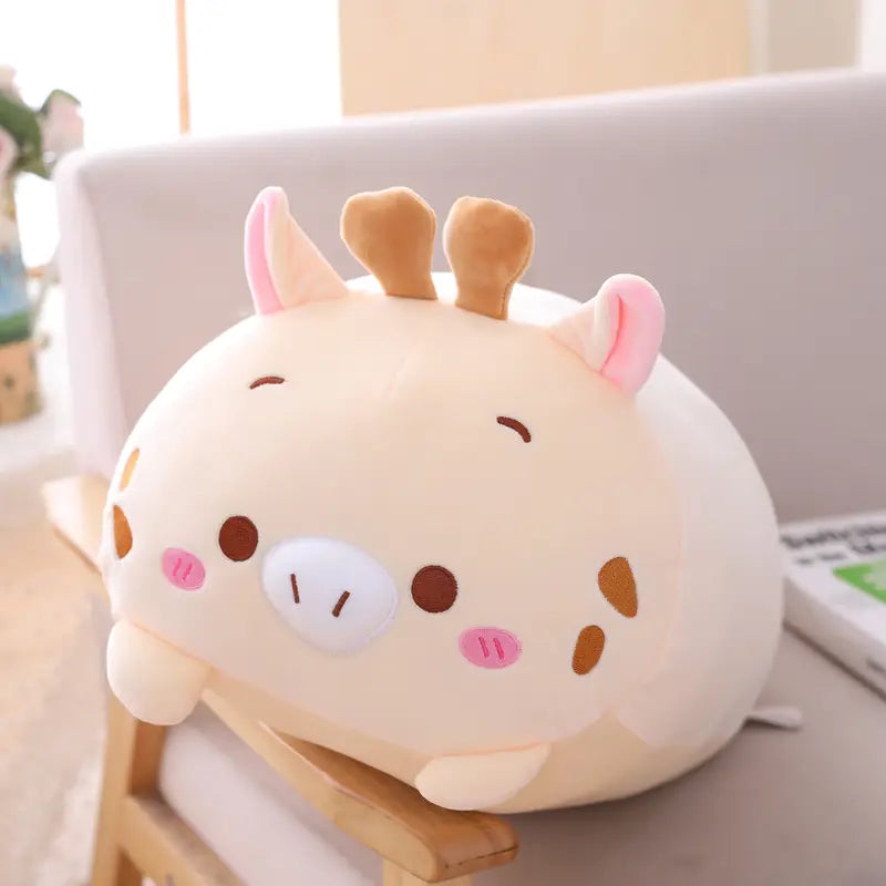 Cream-colored plush giraffe with pink inner ears brown spots and antlers soft stuffed body designed as a plush animal pillow soft cartoon doll for kids.