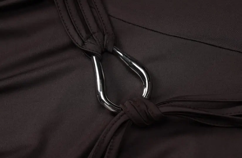 Schulterfreies, gerafftes Minikleid mit Taillengürtel mit dunkelbraunem Lederriemen, an dem ein glänzender silberfarbener Metallkarabiner befestigt ist.