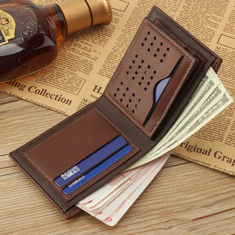 Men’s leather bifold wallet in brown featuring a perforated design with stitched edges, card slots holding blue cards, and a money compartment filled with cash.