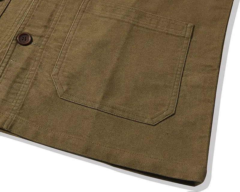 Mens french workwear jacket in olive green canvas with a single brown button and a flap utility pocket made of cotton.