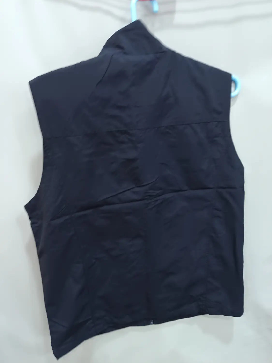 chaleco utilitario impermeable negro sin mangas con múltiples bolsillos, cuello alto y detalles de costura visibles