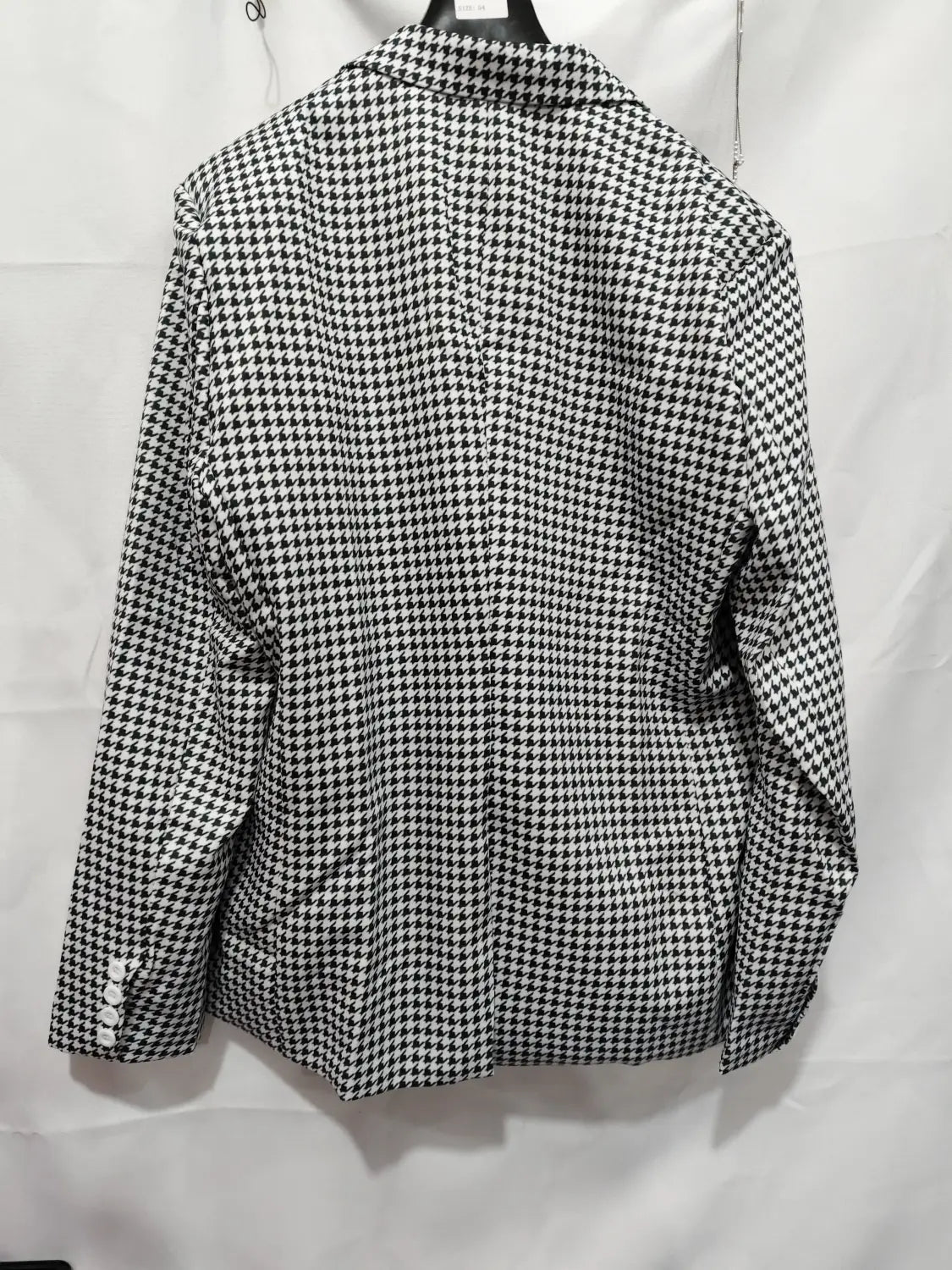 Eine schwarz-weiße Hahnentritt-Slim-Fit-Anzugjacke mit klassischem Kragen und geknöpften Manschetten.