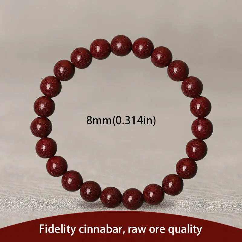 A polished red cinnabar spherical bead bracelet featuring deep red glossy beads with a subtle golden speckled texture.