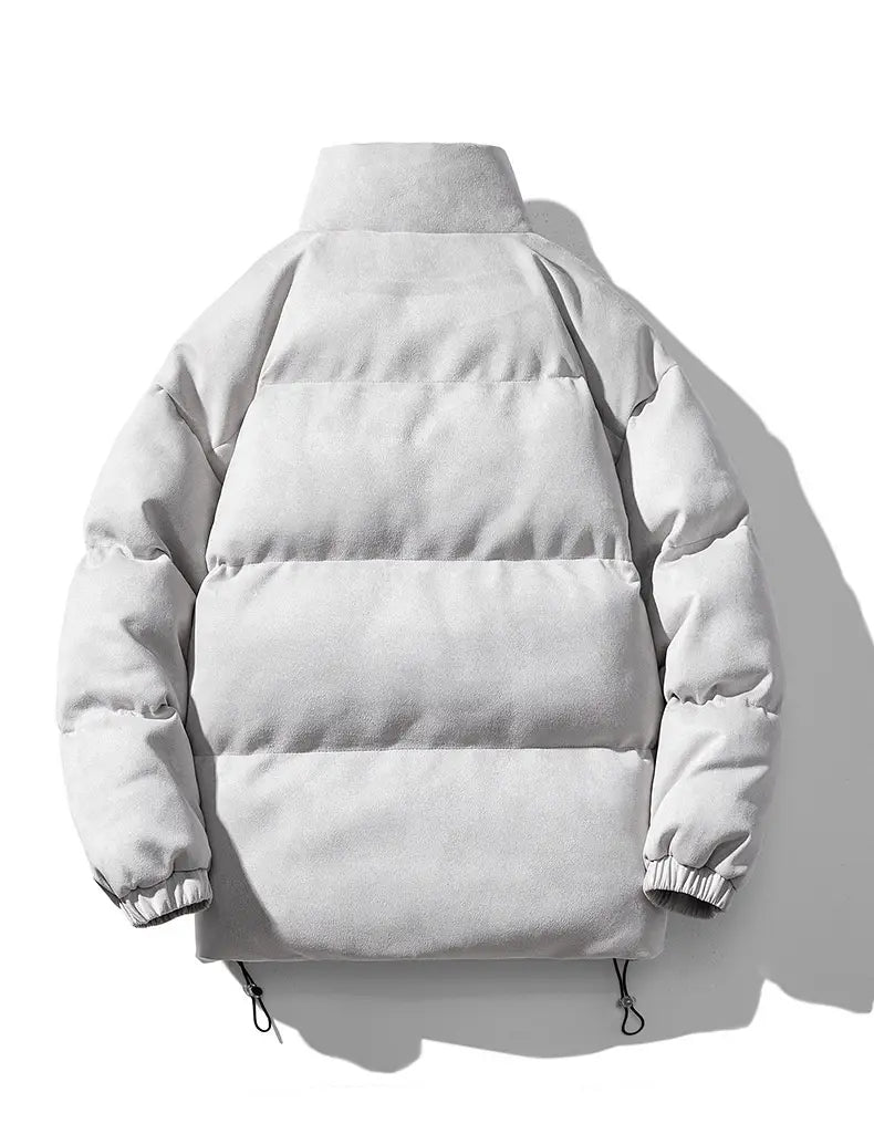 A sleek light gray women thick padded winter coat made of suede in a puffer style with a high collar and ribbed cuffs.