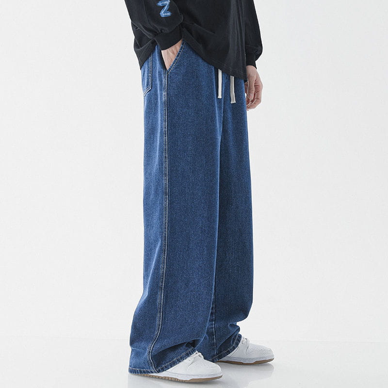 Men’s relaxed fit wide leg denim jeans in blue with white drawstrings and a comfortable drawstring waist.