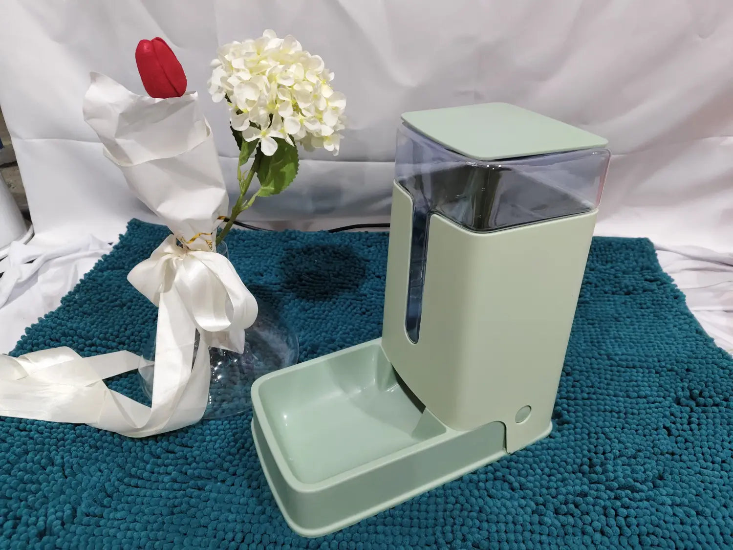 Mint green automatic pet feeder with transparent food compartment and matching water dish for convenient pet feeding and hydration.