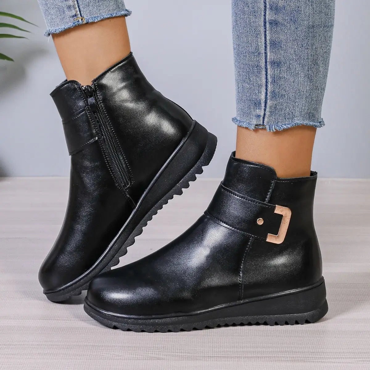 Schwarze Damen-Winter-Fleece-Ankle-Boots aus Leder mit einer Schnalle in Roségold und einer profilierten Gummisohle.