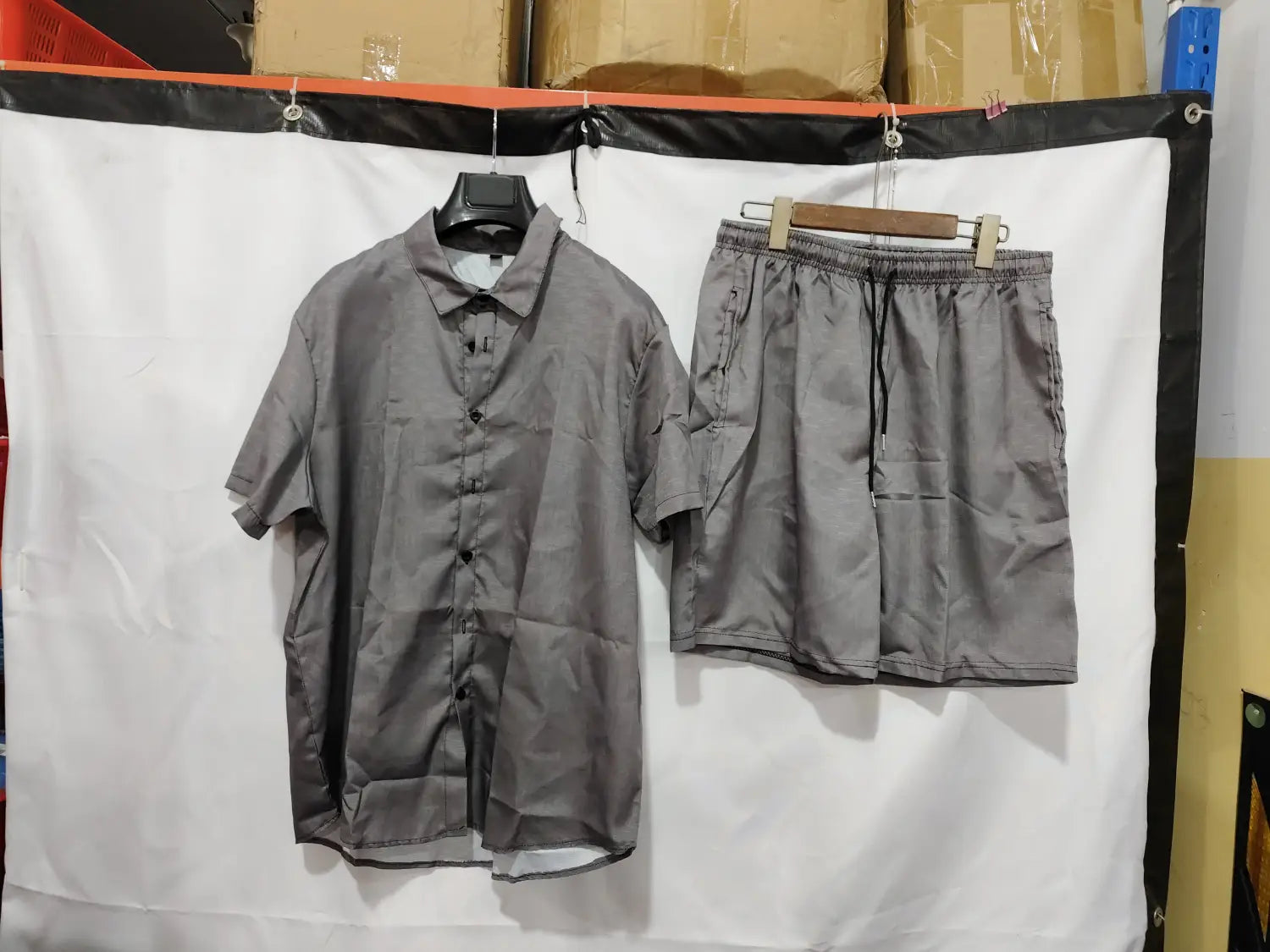 chemise en lin grise boutonnée et ensemble de shorts assortis, en tissu léger, avec une légère brillance pour une tenue décontractée pour homme.