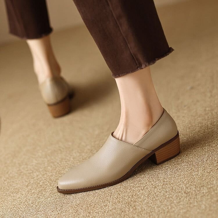 Beige leather slip-on women’s block heel loafers with a square toe and stitched detailing.