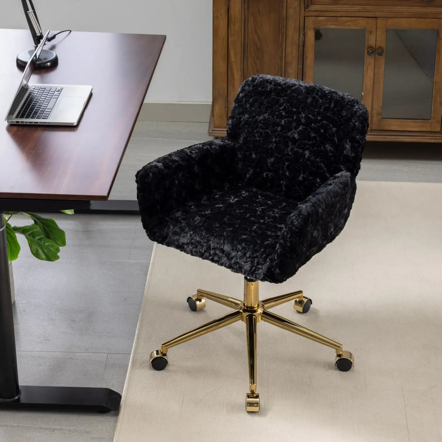Chaise de bureau en fausse fourrure noire présentant un revêtement en velours moelleux, avec une base métallique de ton doré et des roulettes pour la mobilité.
