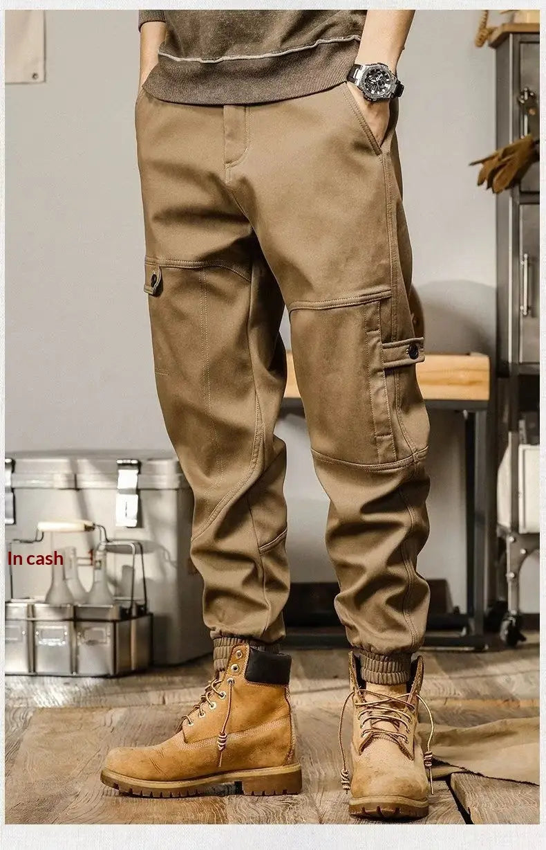 Pantalons cargo pour hommes de couleur tan, à coupe ample, avec plusieurs poches, conçus pour un usage de vêtement de travail décontracté.