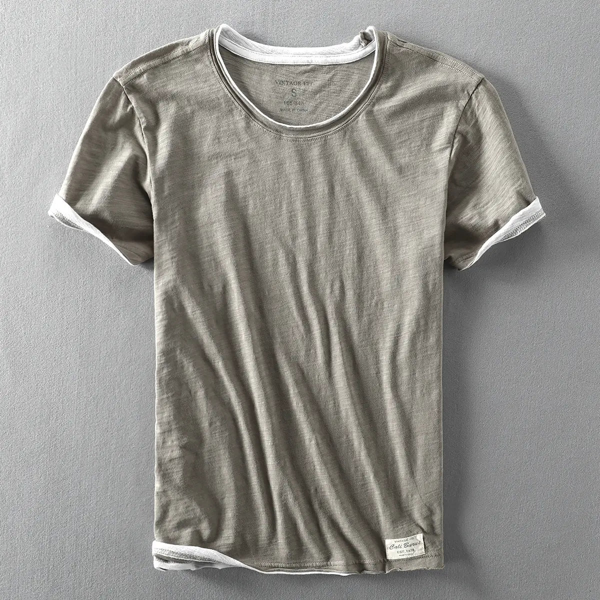 Ein Herren-T-Shirt aus Baumwolle mit Kontrastbesatz in Olivgrün mit weißem Besatz an Kragen, Ärmelsäumen und Saum für Freizeitkleidung im Sommer.