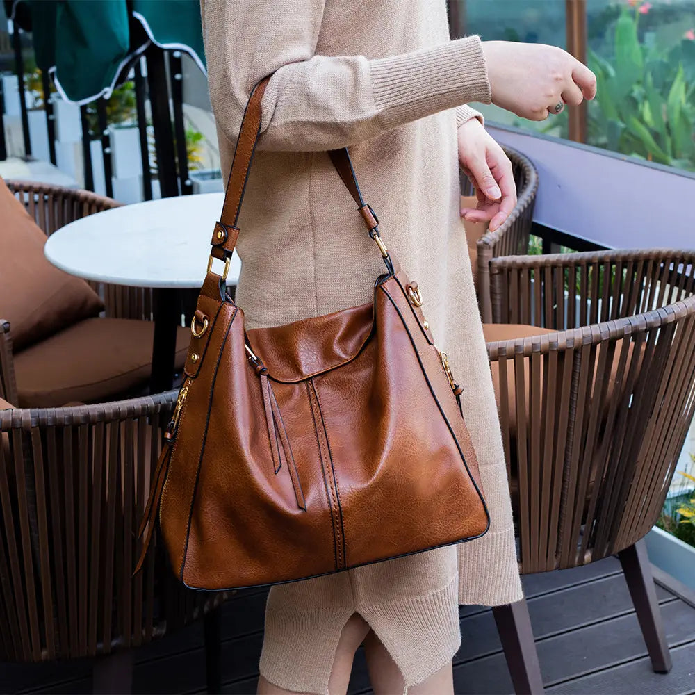 Premium brown leather hobo crossbody bag with gold hardware and flap closure.