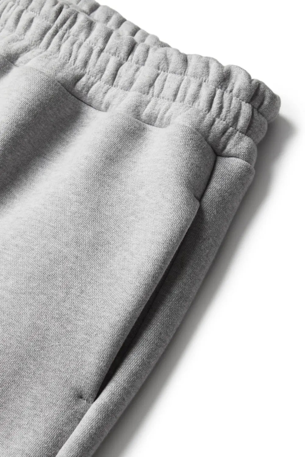 Unisex gray heathered fleece sweatpants with soft textured fabric and an elastic waistband designed for comfortable jogger wear.