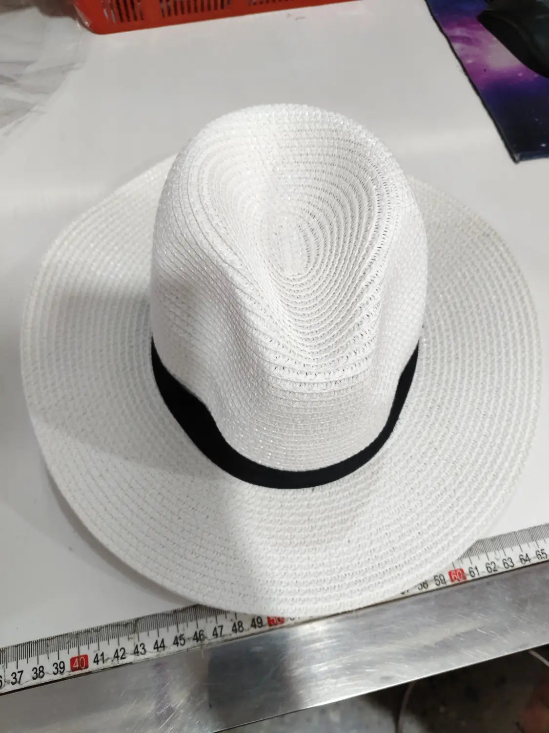 White woven straw fedora hat with a black band foldable for sun protection for men.