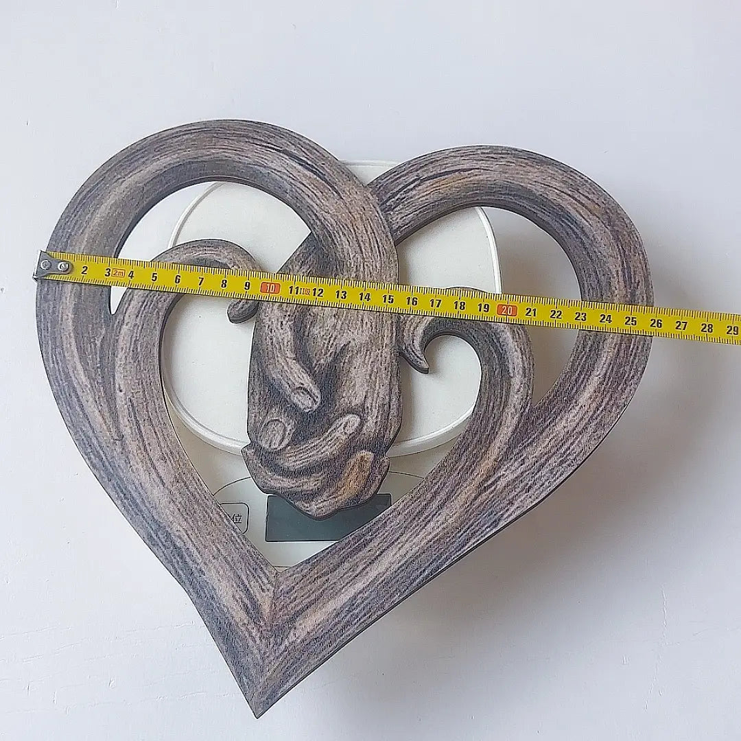 Rustikale herzförmige Wanddekoration aus Holz: ein geschnitztes Design einer Hand, die in ihrer Mitte eine andere Hand hält, aus natürlichem Holz gefertigt.