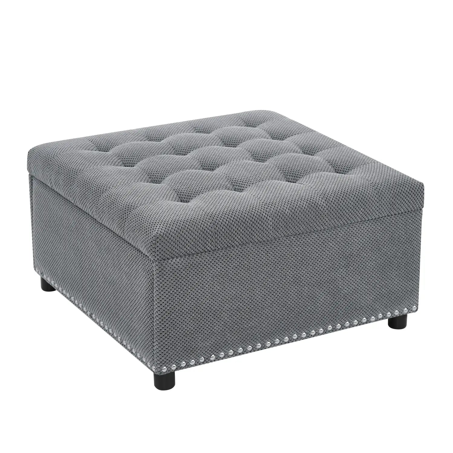 Gray tufted storage ottoman with textured fabric finish and decorative nailhead trim along the base.