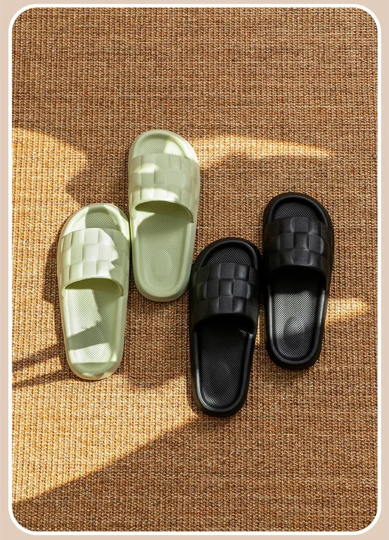 A pair of mint green and black quilted eva soft sole breathable slide sandals with a woven texture and textured rubber sole.