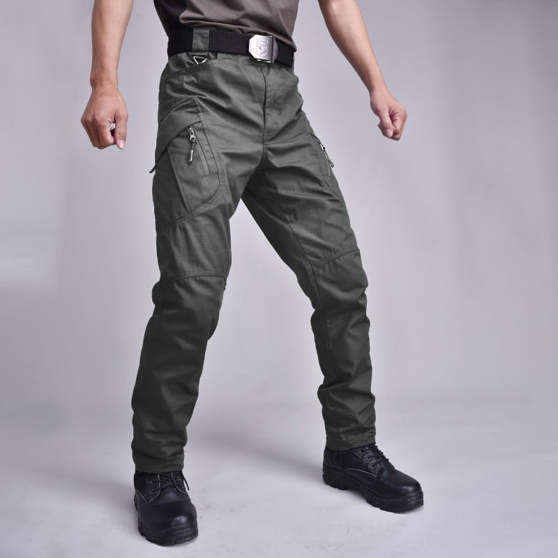 Olive green tactical military combat pants for men with multiple zippered pockets and a black belt designed for durability and functionality.