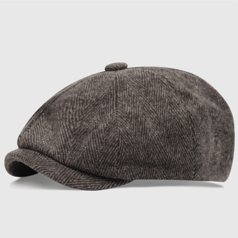 A dark gray herringbone-patterned woolen flat cap with a structured crown and a slightly curved brim from the Herringbone Tweed Flat Cap Octagonal Beret collection.