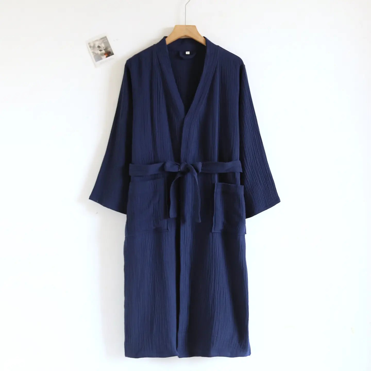Peignoir en gaze de coton bleu marine pour homme, présentant une matière texturée, une ceinture assortie et des poches avant.