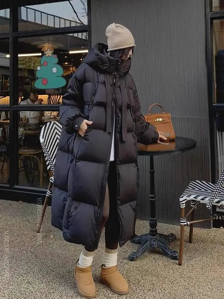 Black long padded down jacket with hood and front zipper made of quilted synthetic insulation fabric designed for women.