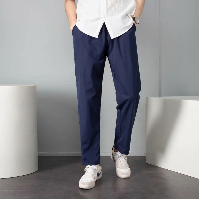 pantalon slim bleu marine à la coupe moderne épurée et à de légers plis, conçu comme un pantalon décontracté court.