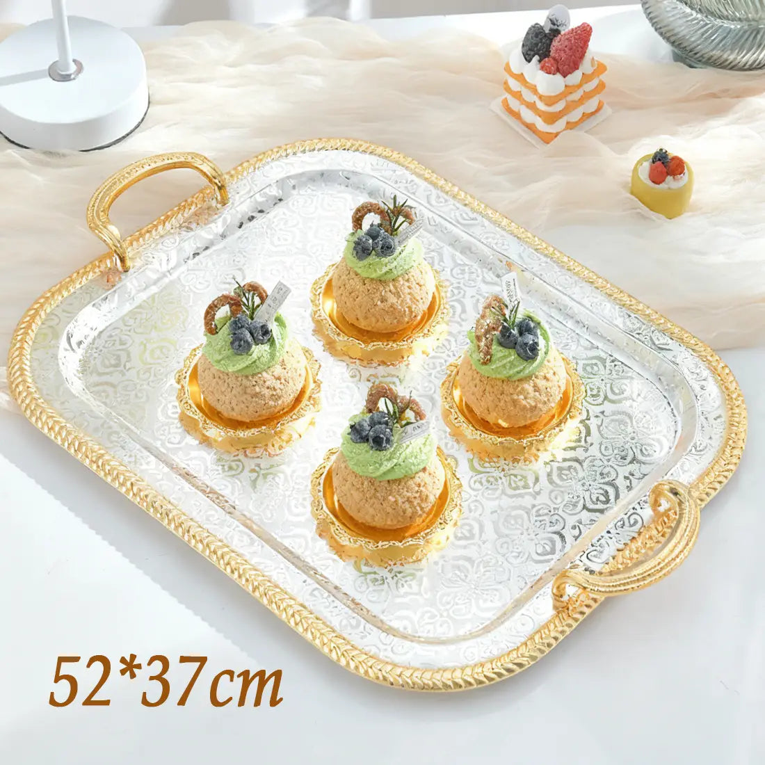 Luxury rectangle serving tray with a silver-plated surface and ornate gold-colored handles featuring an embossed floral pattern along the edges.