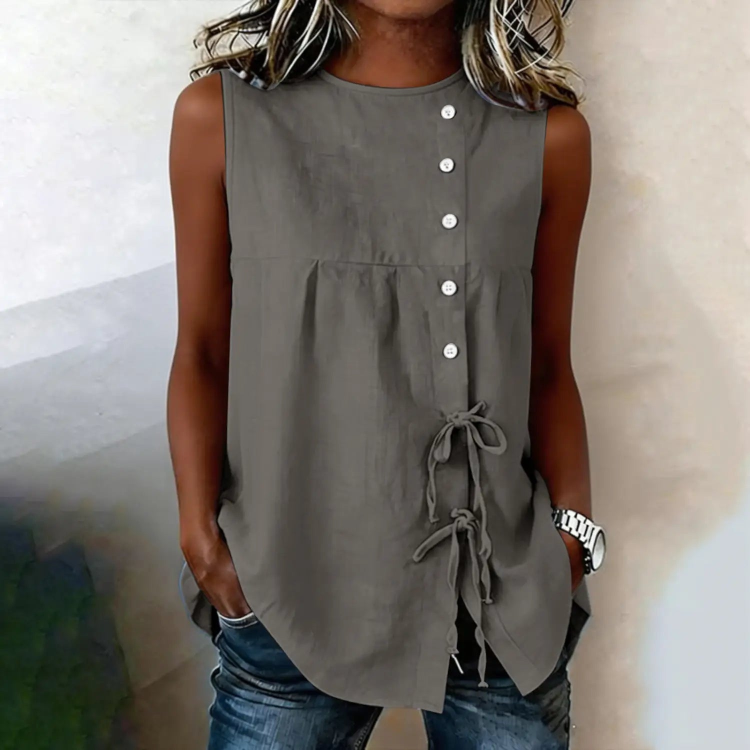 Sleeveless olive-green button-up blouse with gathered waist and tie-side details made from lightweight fabric.