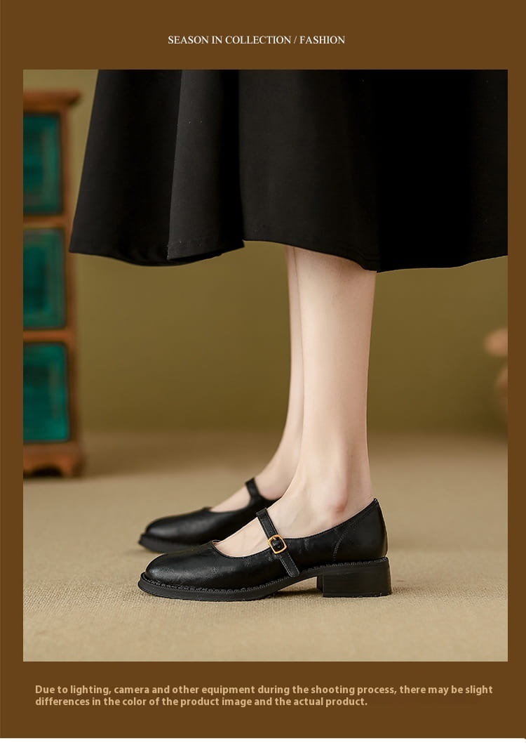 Black leather mary jane shoes with a gold buckle and block heel displayed from the back side.