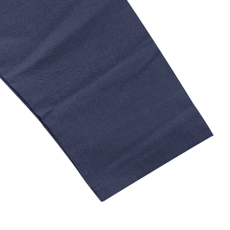 manga de tela azul marino con costuras cuidadas a lo largo del bajo en la sudadera tipo henley relajada de lino para hombre con botones dorados.