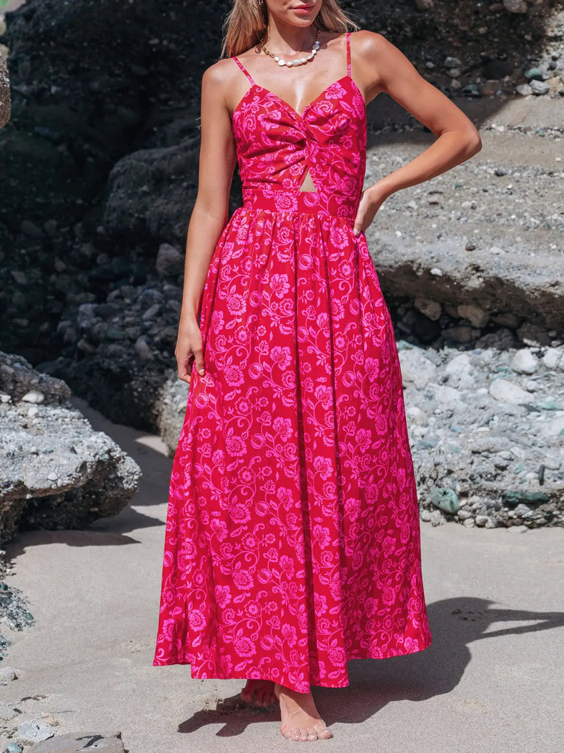 A vibrant pink floral maxi dress with thin spaghetti straps and a front knot detail featuring a v neck design.