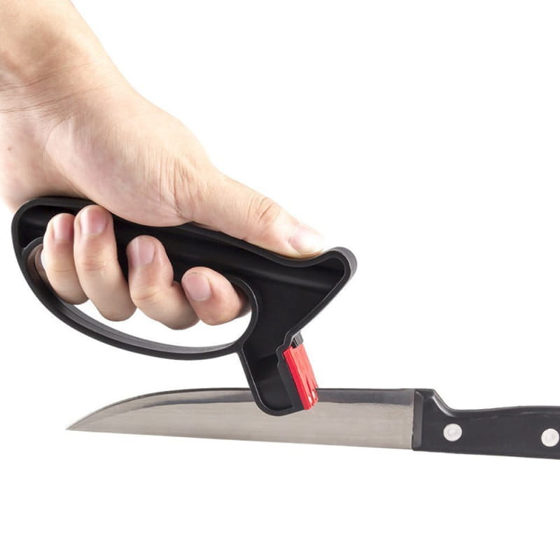 Black plastic knife sharpener with red abrasive insert used on a kitchen knife for knife and scissor sharpening.
