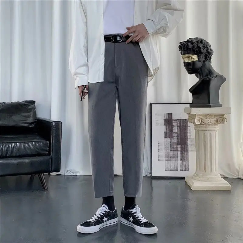 Grau melierte Slim-Fit-Baumwollhosen mit modernem Schnitt und dezenter Faltenbildung entlang der Beine, für Herren konzipiert.