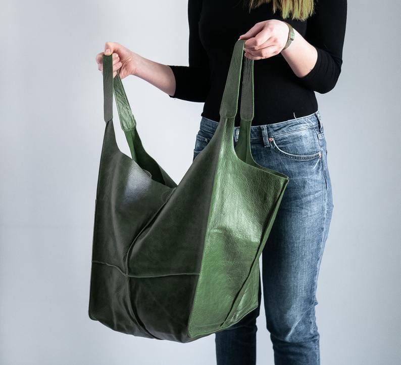 Olive green leather tote bag with large capacity soft slouchy shoulder design and sturdy handles.