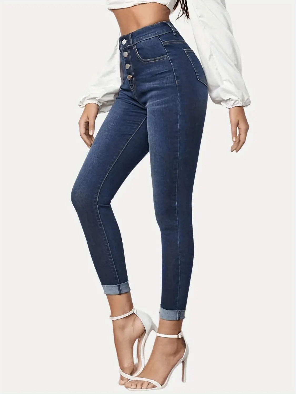 Jeans stretch raccourcis foncés bleus, taille haute, coupe slim, en denim, avec braguette boutonnée et bas de jambe retroussés.