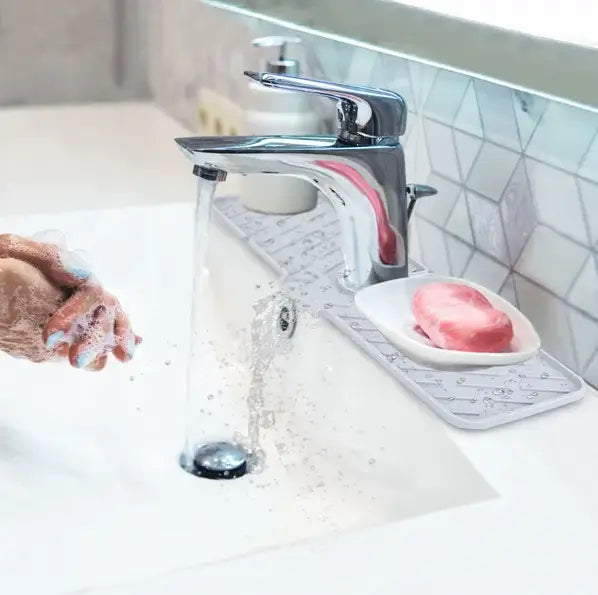 Tapis de robinet en silicone pour évier de cuisine, pare-éclaboussures, avec un robinet à finition chromée présentant un design moderne et épuré.