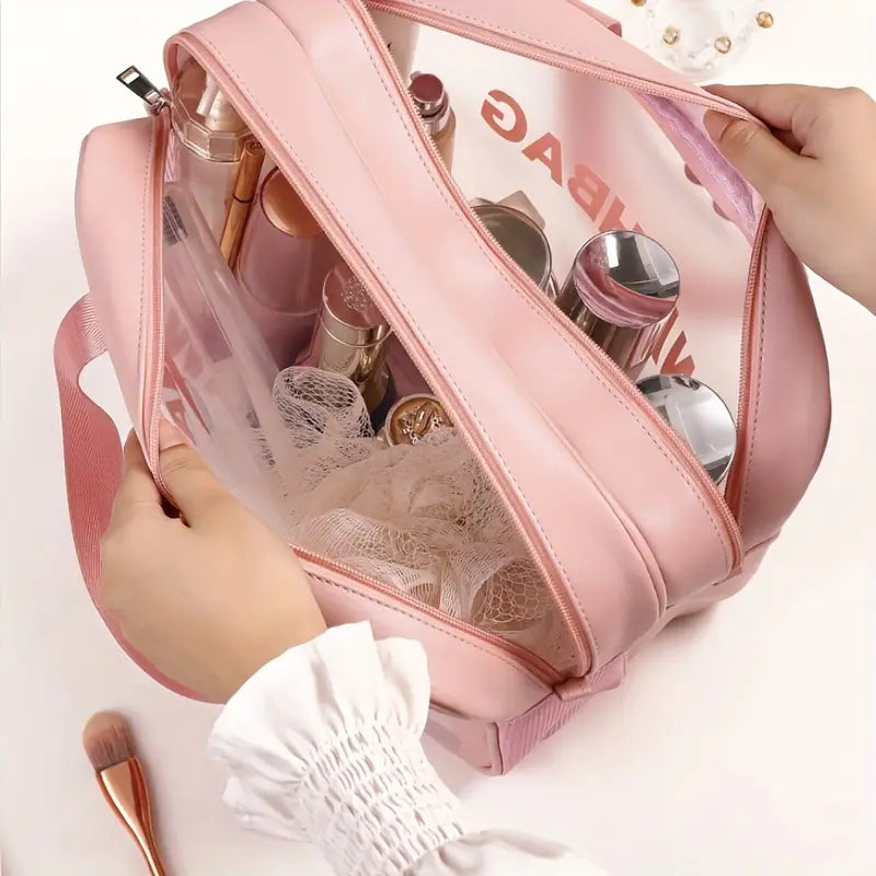 Rosafarbene Kunstleder-Reisekosmetiktasche mit transparenten Seitenpaneelen und Reißverschluss; ausgelegt für Trennung von trocken und nass und zur Organisation der Wäsche.