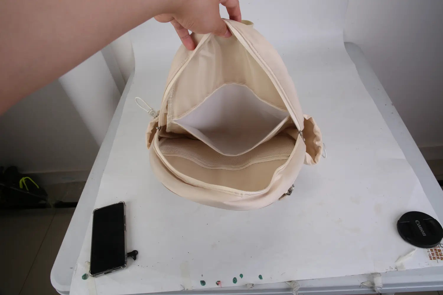 Sac bandoulière pour pickleball matelassé beige, imperméable, avec intérieur en toile souple structurée et détails de fermeture éclair discrets, y compris une poche humide.