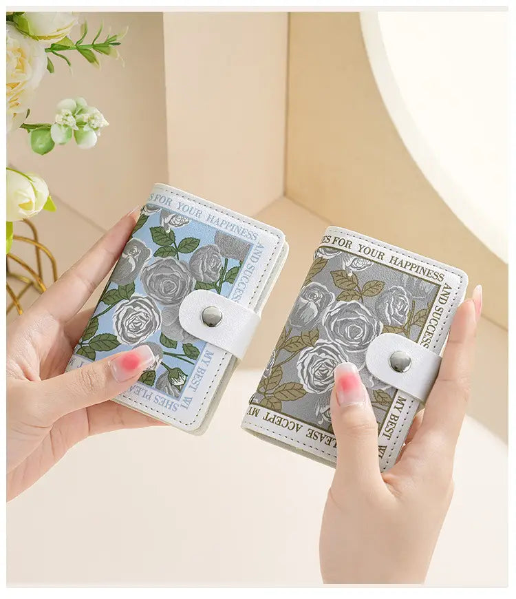 two vintage floral pu leather mini wallets in light blue with gray roses and muted gray with white roses featuring silver-toned snap closures and multiple card slots