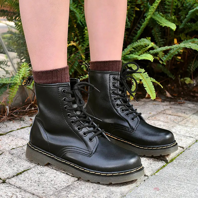 black leather dr martin boots featuring burgundy leather with yellow stitching shown from the back side